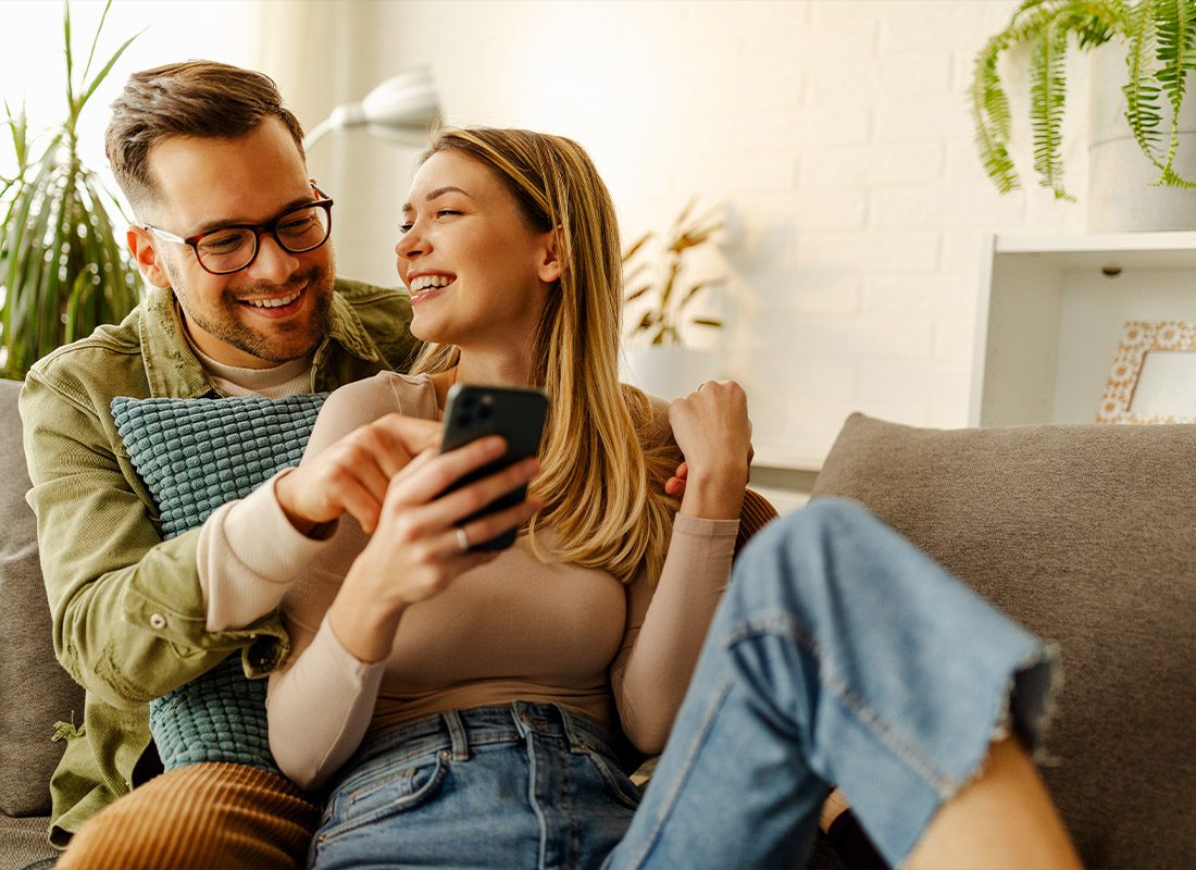 Read Our Reviews - Overjoyed Young Couple Celebrate While Reading Good Unexpected News on Smartphone